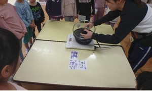 子どもが鍋の中のイエローポップの種を見ている様子