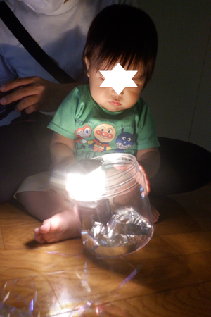0歳児が懐中電灯を手に取って光を見ています