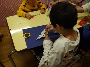 切り絵で表現した「鱗」貼っている様子