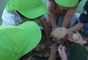 写真：米ぬかに水を加えた米ぬか粘土で遊ぶ子どもたち