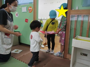 5歳児が新入園児にプレゼントをわたす様子