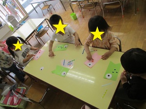 2歳児クラスがシールを貼ってこいのぼりを作っている様子