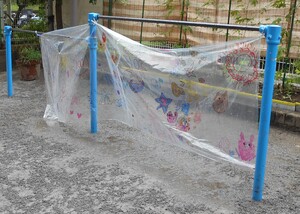作った的を鉄棒にぶら下げています。