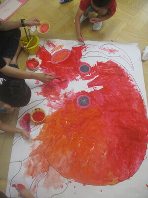 タコの絵に色を塗る子どもと保育士