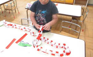 タコの足を輪つなぎで作る子ども