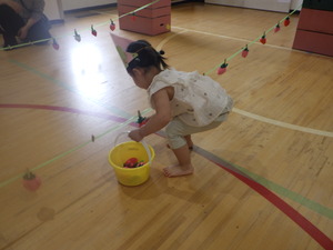 いちごの帽子をかぶり、いちご狩りごっこを楽しむ子どもの姿