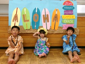 2歳児1名、5歳児2名がサーフボードのフォトコーナーで写真撮っているところ