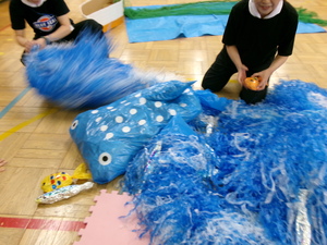 水に見立てた水色のスズランテープの中にさんまや他の魚が見えている写真