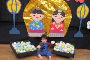 フォトコーナー　雛あられの傍で写真を撮る幼児