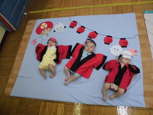 赤ちゃんが寝転んだ夏まつりのフォトを撮る様子
