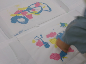 写真:ビニールの上から絵具を踏んで遊ぶ様子