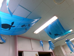 写真:天井から子どもたちの作ったクラゲを吊るしている