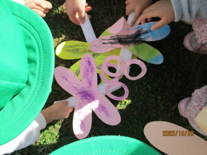 砂にトンボをかざす子どもたち