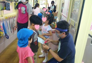 子どもたちが保育士からスタンプをもらっている様子