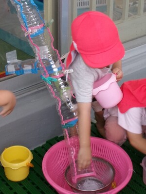 春雨をペットボトルでできた樋に流すところ