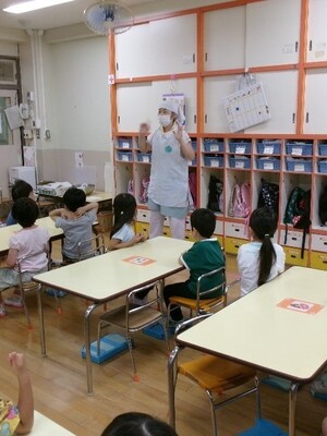 そら豆の皮むきの話を聞くみかん組の子どもたち