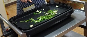 ホットプレートで野菜を炒めている