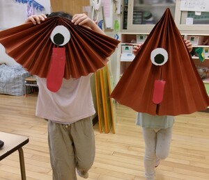 からかさおばけの面をつけている子ども