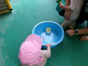 タライで水遊びしている子ども
