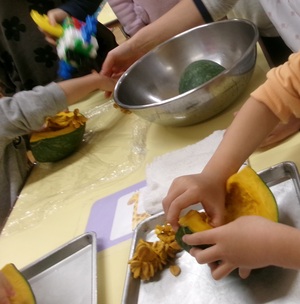 栄養士と一緒に種取りをする子どもたちの写真