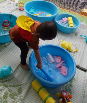 写真:子どもがタライの水をまぜているところ