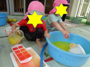 写真:水遊びをする1、2歳児の子どもたち
