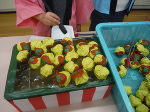 焼き台にたこ焼きをのせてたこ焼きを作っています