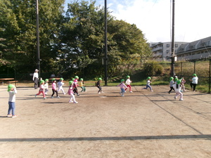 公園の広場でだるまさんがころんだをする子どもたち