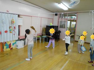 天井から羽根つきの無患子をつるし、お友達と打ち合いをする様子