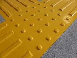 屋外の黄色い誘導用ブロックの写真