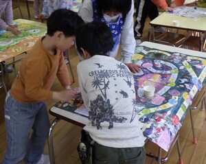子どもがすごろくで遊んでいる姿です。