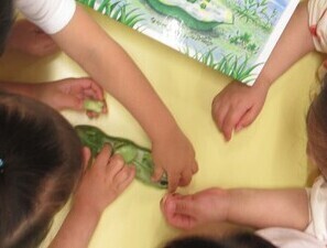 子どもたちが絵本のそら豆と実物のそら豆を見比べる様子