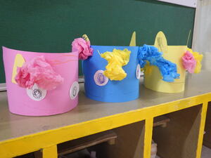 2歳児クラスが作った鬼の写真。画用紙で作った顔に花紙を丸めた髪の毛が付いており、頭に被れるようになっている。