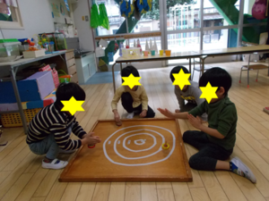 写真:コマ回しをしている子どもたち