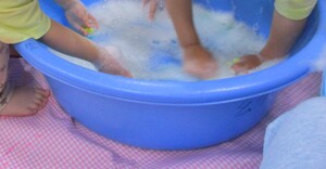 タライに入った泡の感触を楽しんでいます