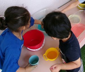 色水に触れる3歳児