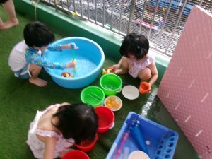 ベランダで水遊びをする4歳児