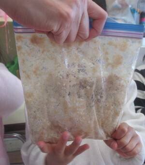 蒸した大豆を潰しています。