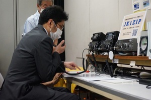 画像：無線交信を体験する太田課長