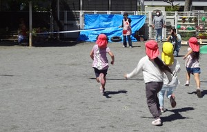 写真:園庭を走っている子どもの様子。