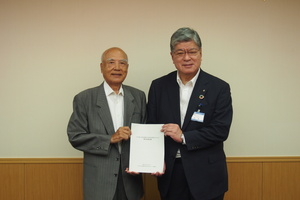 岡田会長が坂本区長に報告書を提出している写真