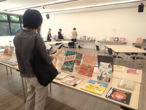 展示会で絵本を見る人